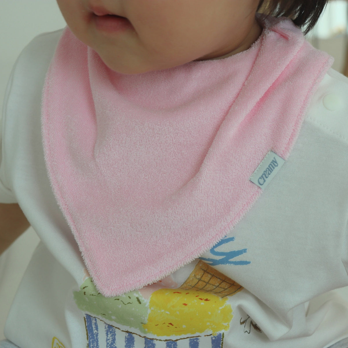 Baby wearing Creamy Gelato Bib in Strawberry