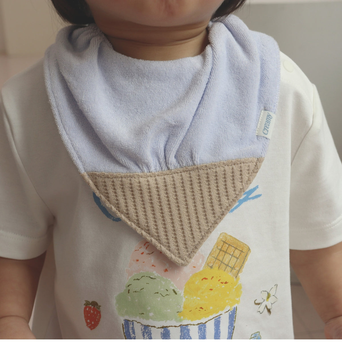 Baby wearing Creamy Vanilla Cone Bib